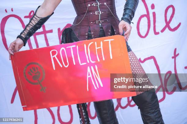 August 2020, Baden-Wuerttemberg, Stuttgart: A participant holds a sign saying "Red light on" during a demonstration on the ban of sex workers during...