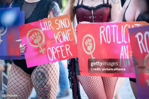 August 2020, Baden-Wuerttemberg, Stuttgart: One participant holds signs saying "We are not victims" during a demonstration on the ban of sex workers...