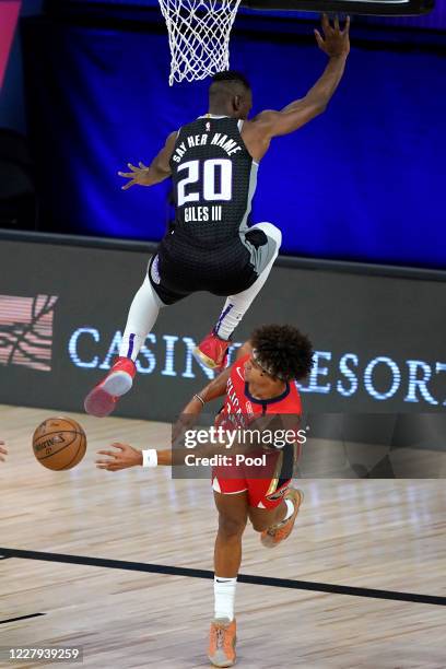 Harry Giles III of the Sacramento Kings leaps over Frank Jackson of the New Orleans Pelicans after Jackson slipped while driving to the basket during...