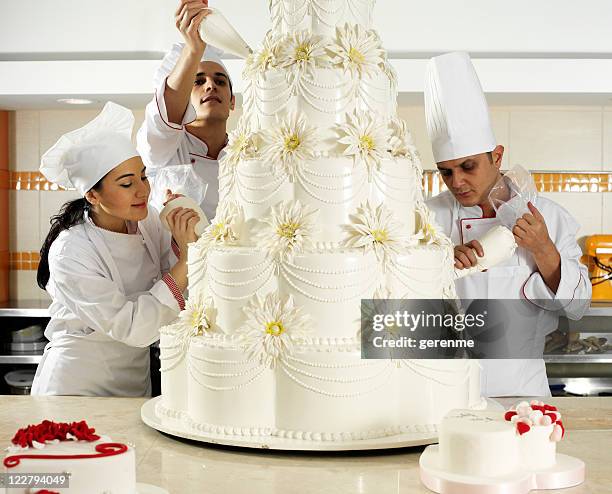 team spirit in pastry - finishing cake stock pictures, royalty-free photos & images