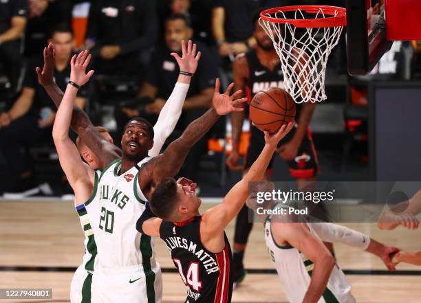 Miami Heat guard Tyler Herro moves to the basket against Milwaukee Bucks forward Marvin Williams during the first half of an NBA basketball game at...