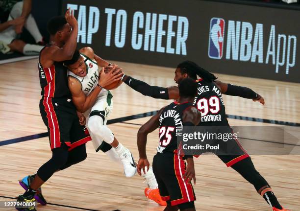 Milwaukee Bucks forward Giannis Antetokounmpo moves to the basket against the defense of Miami Heat forward Bam Adebayo forward Jae Crowder and guard...