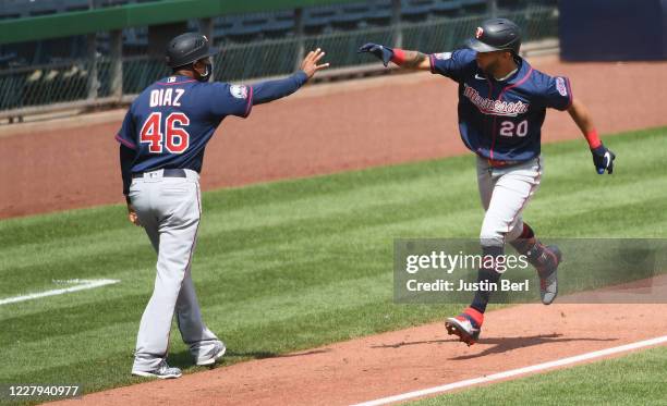 Eddie Rosario of the Minnesota Twins celebrates with third base coach Tony Diaz as he rounds the bases after hitting a home run in the fifth inning...