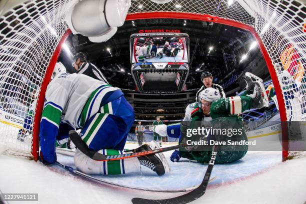 Tyler Myers of the Vancouver Canucks battles against Luke Kunin of the Minnesota Wild as Oscar Fantenberg falls during the second period in Game...