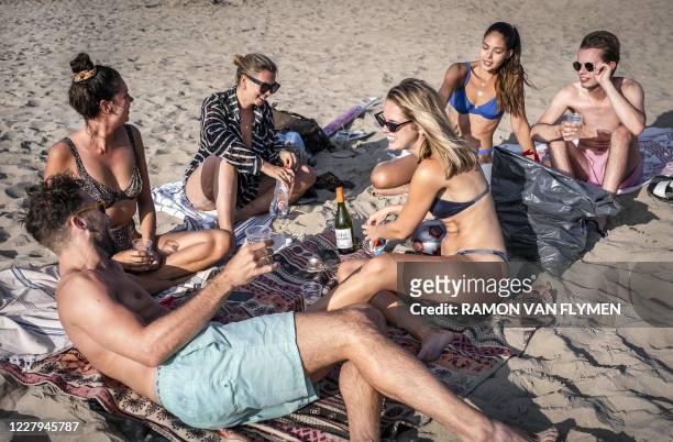 In this photograph taken on August 6 a group of young people gather on the beach at Zandvoort, as a period of warm weather prevails across northern...