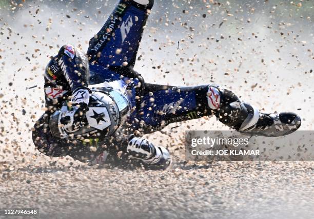 Monster Energy Yamaha's Spanish rider Maverick Vinales rolls on the ground after he crashed during the first training session ahead of the Moto GP...