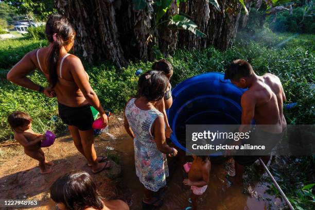 July 2020, Brazil, Sao Gabriel da Cachoeira: A group of the Yanomami indigenous community is cleaning the only water tank they have in the middle of...