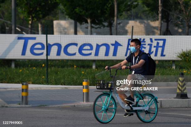 Man walks past a sign for Tencent, the parent company of Chinese social media giant WeChat, outside the Tencent headquarters in Beijing on August 7,...
