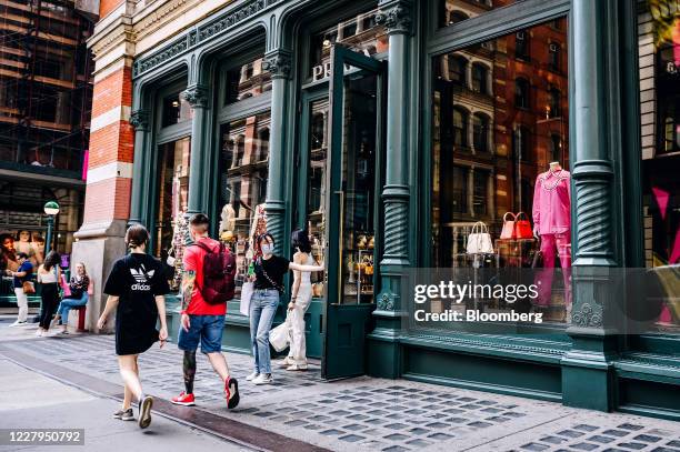 Shoppers wearing protective masks exits from a Prada store in the Soho neighborhood of New York, U.S., on Thursday, Aug. 6, 2020. The Bloomberg...