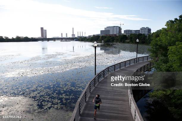 Runner jogs along a Mystic River Reservation footbridge at Sylvester Baxter Park in Somerville, MA on Aug. 3, 2020.