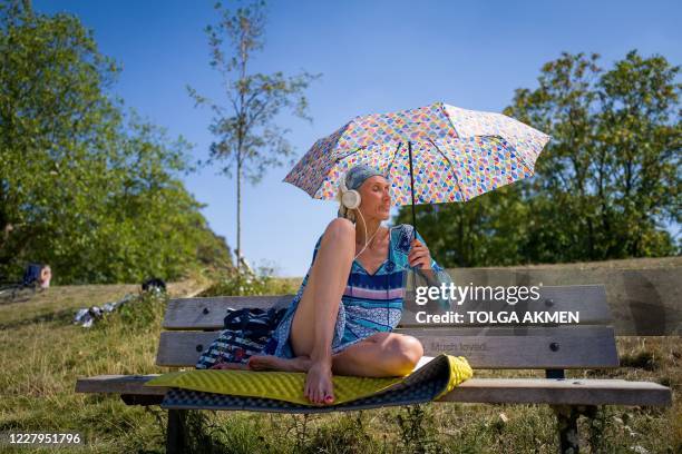 People enjoy the sunshine as they sunbathe at Hampstead Heath ponds as the temperature soars in London on August 7, 2020.