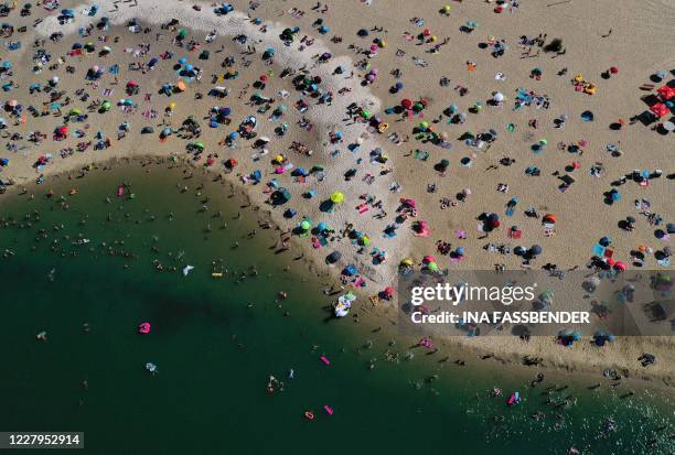 An aerial view shows people cooling off at the Silbersee 2 lake in Haltern am See, western Germany on August 7, 2020 as temperatures topped 36...