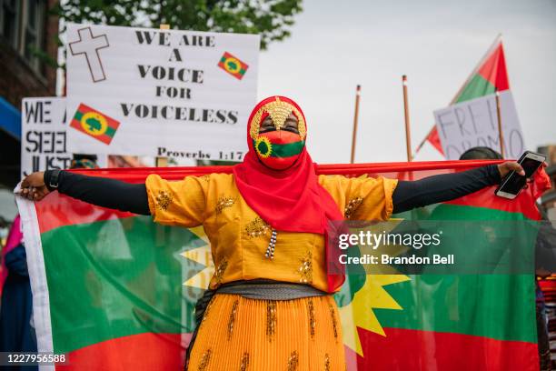 Woman marches with the Oromo flag outstretched on August 7, 2020 in St. Paul, Minnesota. Members of the Oromo community participated in a silent...