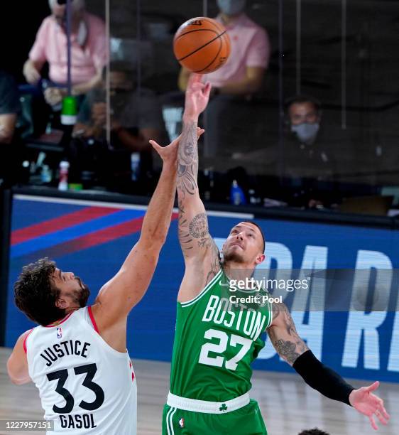 Marc Gasol of the Toronto Raptors and Daniel Theis of the Boston Celtics go up for the opening tipoff during the first half of an NBA basketball game...