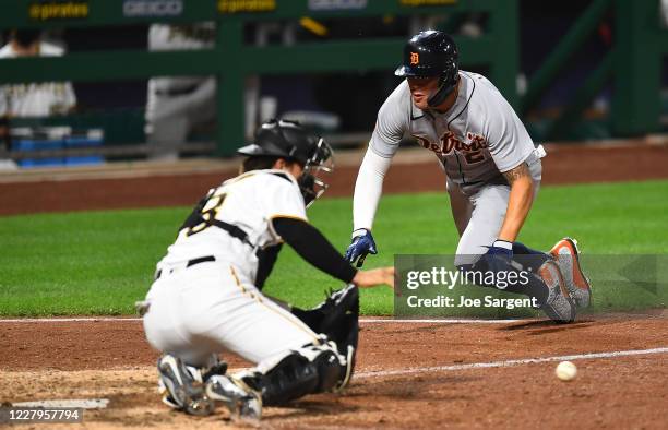 JaCoby Jones of the Detroit Tigers scores in front of John Ryan Murphy of the Pittsburgh Pirates during the tenth inning at PNC Park on August 7,...