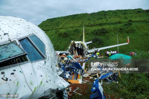 Officials inspect the wreckage of an Air India Express jet at Calicut International Airport in Karipur, Kerala, on August 8, 2020. - Fierce rain and...