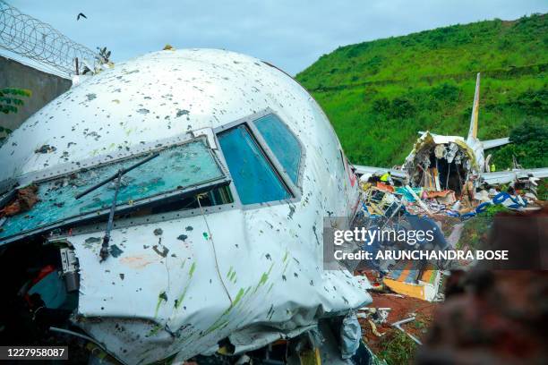Officials inspect the wreckage of an Air India Express jet at Calicut International Airport in Karipur, Kerala, on August 8, 2020. - Fierce rain and...