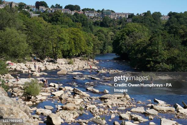 People enjoy the hot weather at Richmond Falls on the River Swale, North Yorkshire.