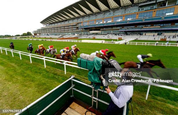 General view as runners and riders competing in the Dubai Duty Free Millennium Millionaire Handicap pass an ITV Racing cameraman on their way out on...