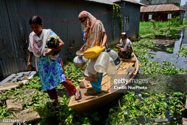 Citizens ride on a boat through flood water at Lowland area of the Dhaka City in Bangladesh, on August 8, 2020.