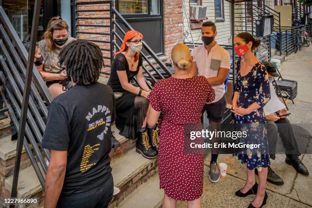 Tasha Rose seen talking to Community organizer Samy Nemir Olivares and State Senator Julia Salazar at the gathering. A crowd of supporters including...