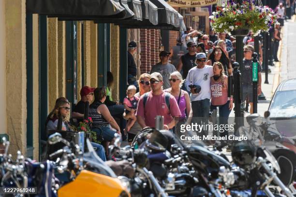 People walk through downtown Deadwood, South Dakota during the 80th Annual Sturgis Motorcycle Rally on August 8, 2020. While the rally usually...