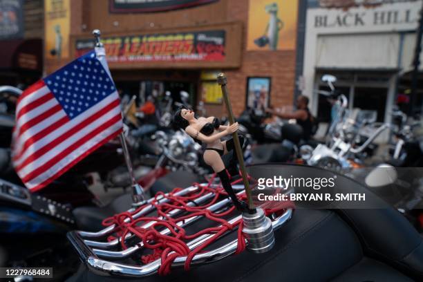 Figurine of a woman and a US flag adorn a bike as motorcyclists ride on Main Street during the 80th Annual Sturgis Motorcycle Rally on August 8, 2020...