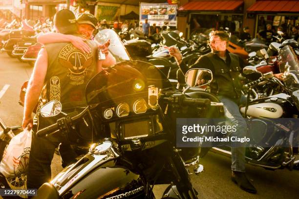 Motorcyclists embrace during the 80th Annual Sturgis Motorcycle Rally in Sturgis, South Dakota on August 8, 2020. While the rally usually attracts...
