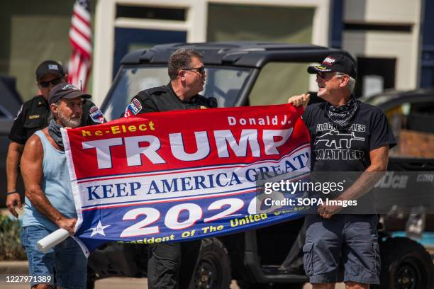 Members of the Martinsville Police Department stop men from carrying a Trump flag into the space during the demonstration at the Morgan County...