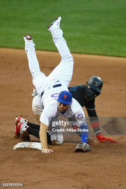 Brian Dozier of the New York Mets falls over Monte Harrison of the Miami Marlins to complete a double play in the second inning at Citi Field on...