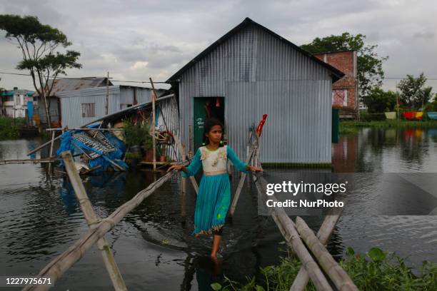 Flood affected girl walks through floodwater on the outskirts of Dhaka, Bangladesh on August 9, 2020.