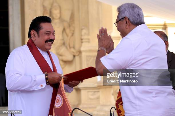 Sri Lankan president Gotabaya Rajapaksa hands over the appointment documents to his brother, former president, Mahinda Rajapaksa who took oaths as...