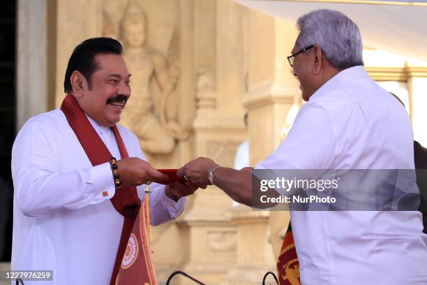 Sri Lankan president Gotabaya Rajapaksa hands over the appointment documents to his brother, former president, Mahinda Rajapaksa who took oaths as...