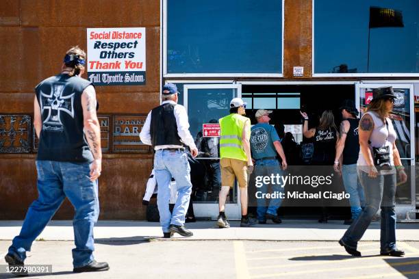 Sign about social distancing sits outside the Full Throttle Saloon during the 80th Annual Sturgis Motorcycle Rally in Sturgis, South Dakota on August...