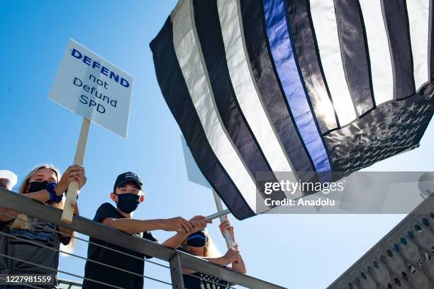 Man waves a Thin Blue Line flag during the Seattle Police Officers Guildâs rally to stop defunding of the Seattle Police Department on Sunday, August...