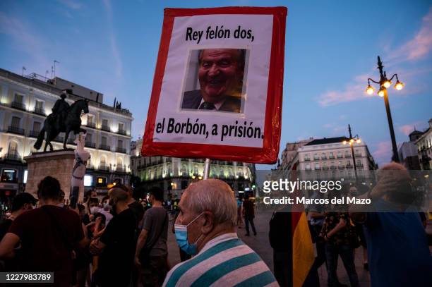 Man protesting during a demonstration against the monarchy with a picture of former king of Spain Juan Carlos I. People have protested calling for a...