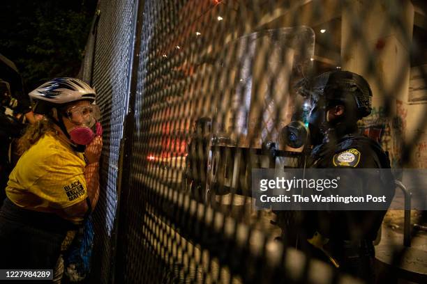 Protester is seen looking through the fence in front of the Mark O. Hatfield U.S. Courthouse on July 24, 2020 in Portland, Oregon. (Photo by Paula...
