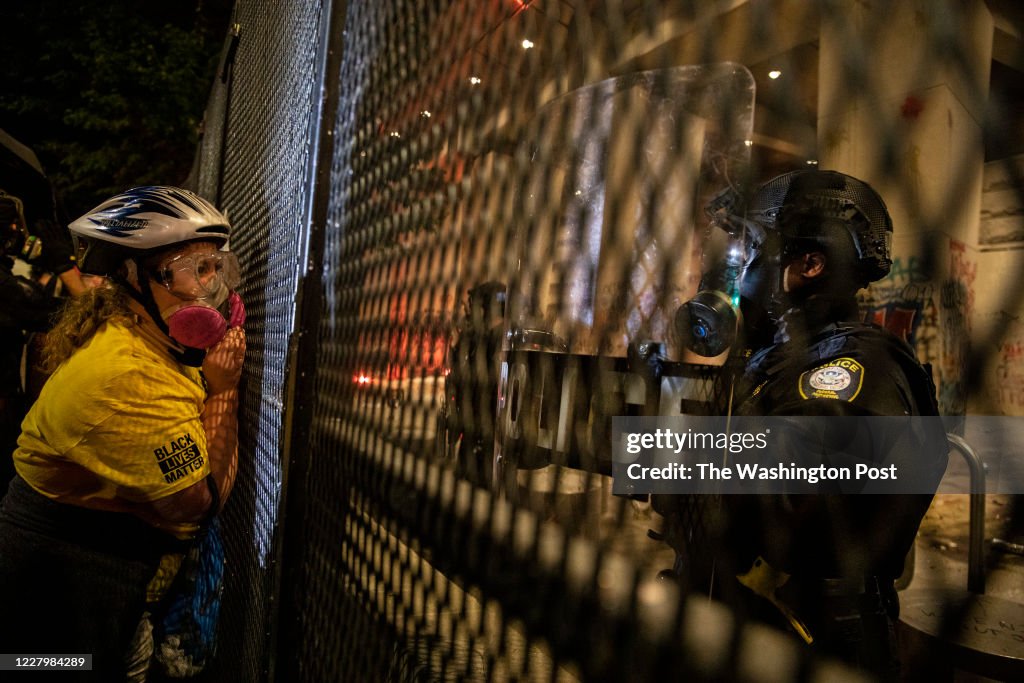 PORTLAND, OR - JULY 24:  A protester is seen looking through th