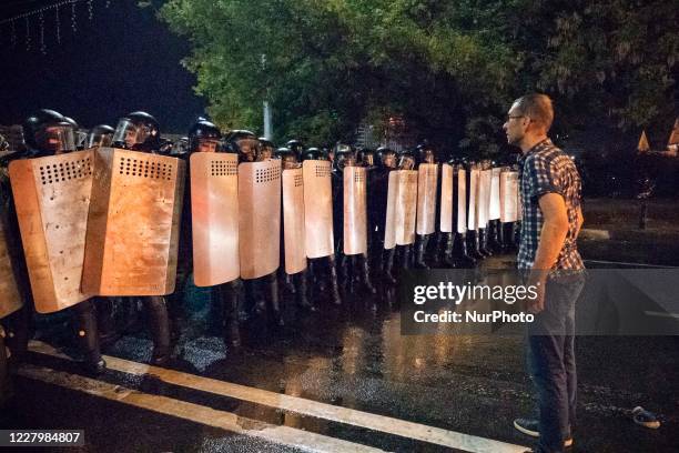 Protester stands in front of the riot police in a public unrest started in the streets of Minsk, Belarus, on August 9, 2020 at the end of the voting...