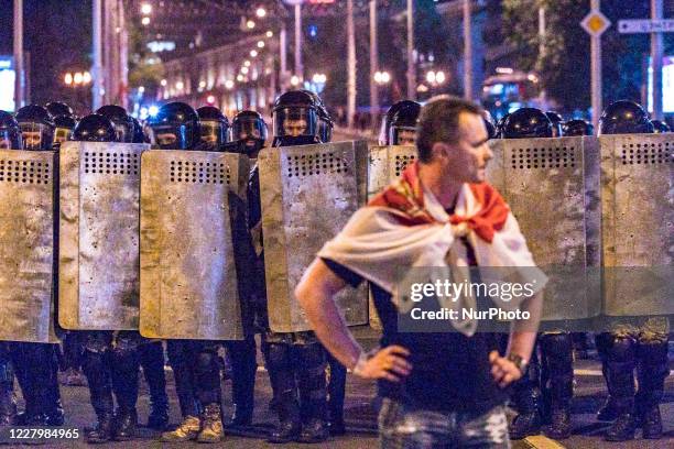 Protester stands in front of the riot police during a public unrest in the streets of Minsk, Belarus, on August 9, 2020 at the end of the voting day...