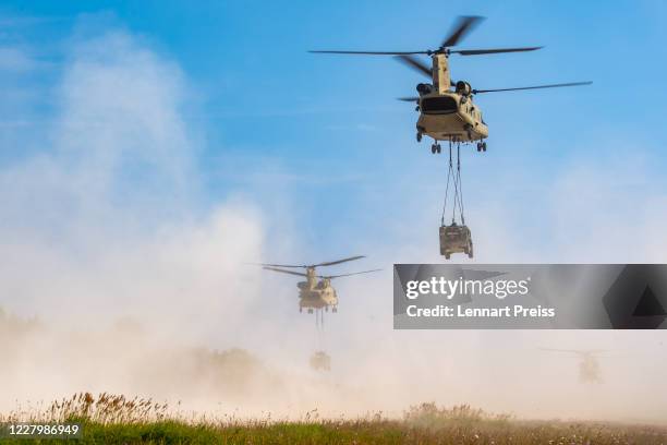 Chinook CH-47 helicopters transport humvee military vehicles during in the Saber Junction 20 military exercises at the Hohenfels training grounds on...