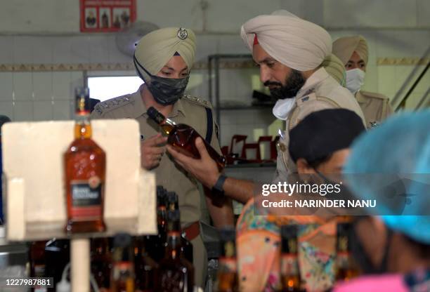 Punjab Police officers and district Administration officials inspect the quality of liquors at a distillery, following a toxic bootleg alcohol...