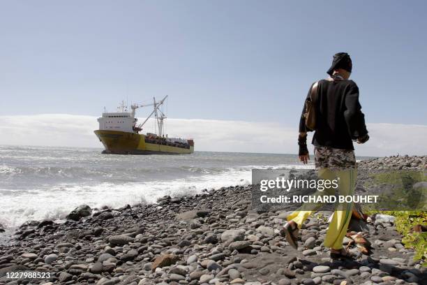 Un homme passe, le 07 août 2005, devant un navire roulier de 9.000 tonnes transportant des conteneurs et des véhicules qui s'est échoué à 20 m des...