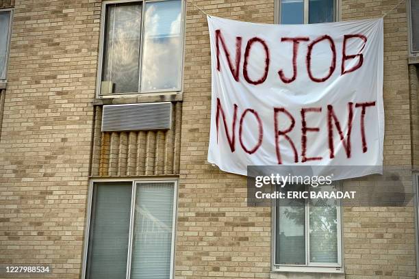 Banner against renters eviction reading no job, no rent is displayed on a controlled rent building in Washington, DC on August 9, 2020. - With double...