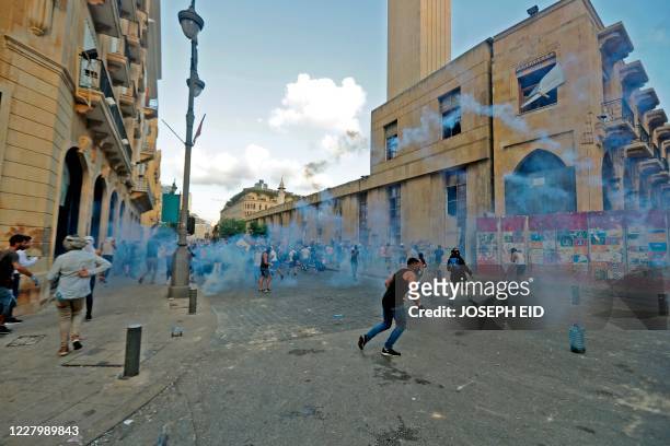 Lebanese security forces fire tear gas to disperse protesters amid clashes in the vicinity of the parliament in central Beirut on August 10 following...