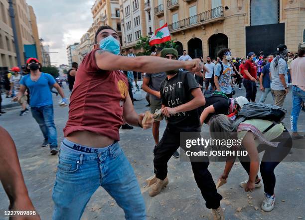 Lebanese protesters, enraged by a deadly explosion, hurl stones at security forces amid clashes in the vicinity of the parliament in central Beirut...