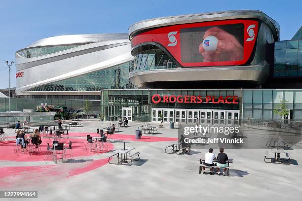 Players and staff watch the second phase of the NHL draft lottery as they sit in the recreation area outside Rogers Place on August 10, 2020 during...