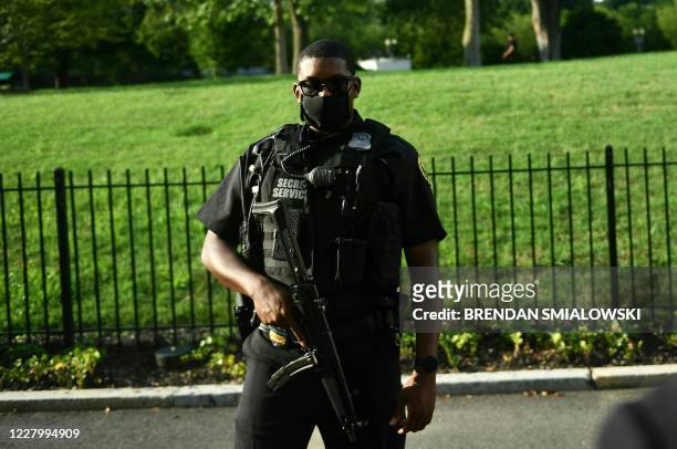 Member of the US Secret Service takes up position outside the Brady Briefing Room as the White House is locked down in Washington, DC, on August 10,...