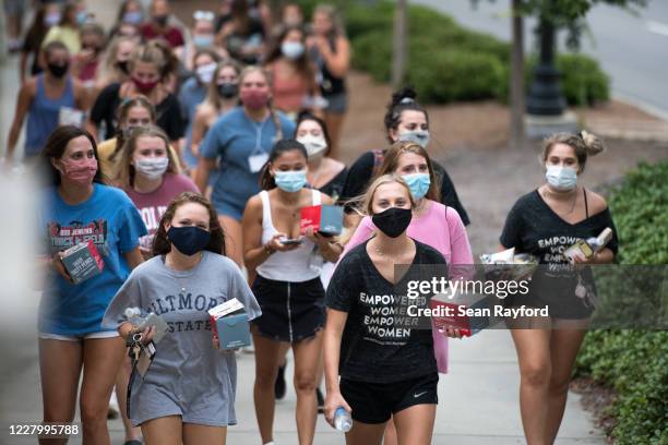 College students walk to dinner at the University of South Carolina on August 10, 2020 in Columbia, South Carolina. Students began moving back to...