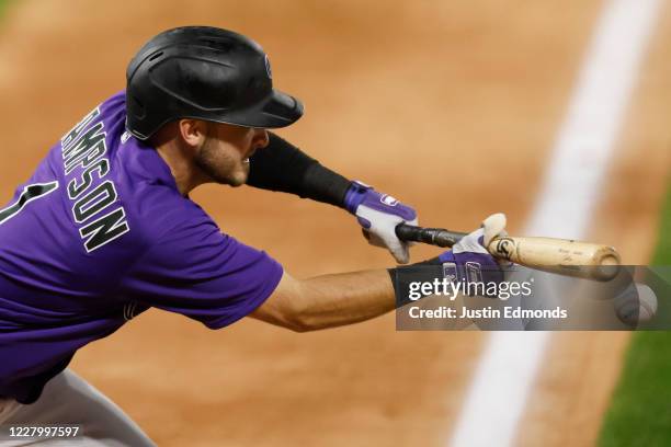 Garrett Hampson of the Colorado Rockies drops a bunt for an infield single during the fourth inning against the Arizona Diamondbacks at Coors Field...